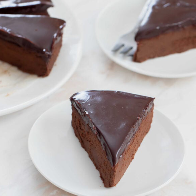 Slices of chocolate cake on white plates with a light background